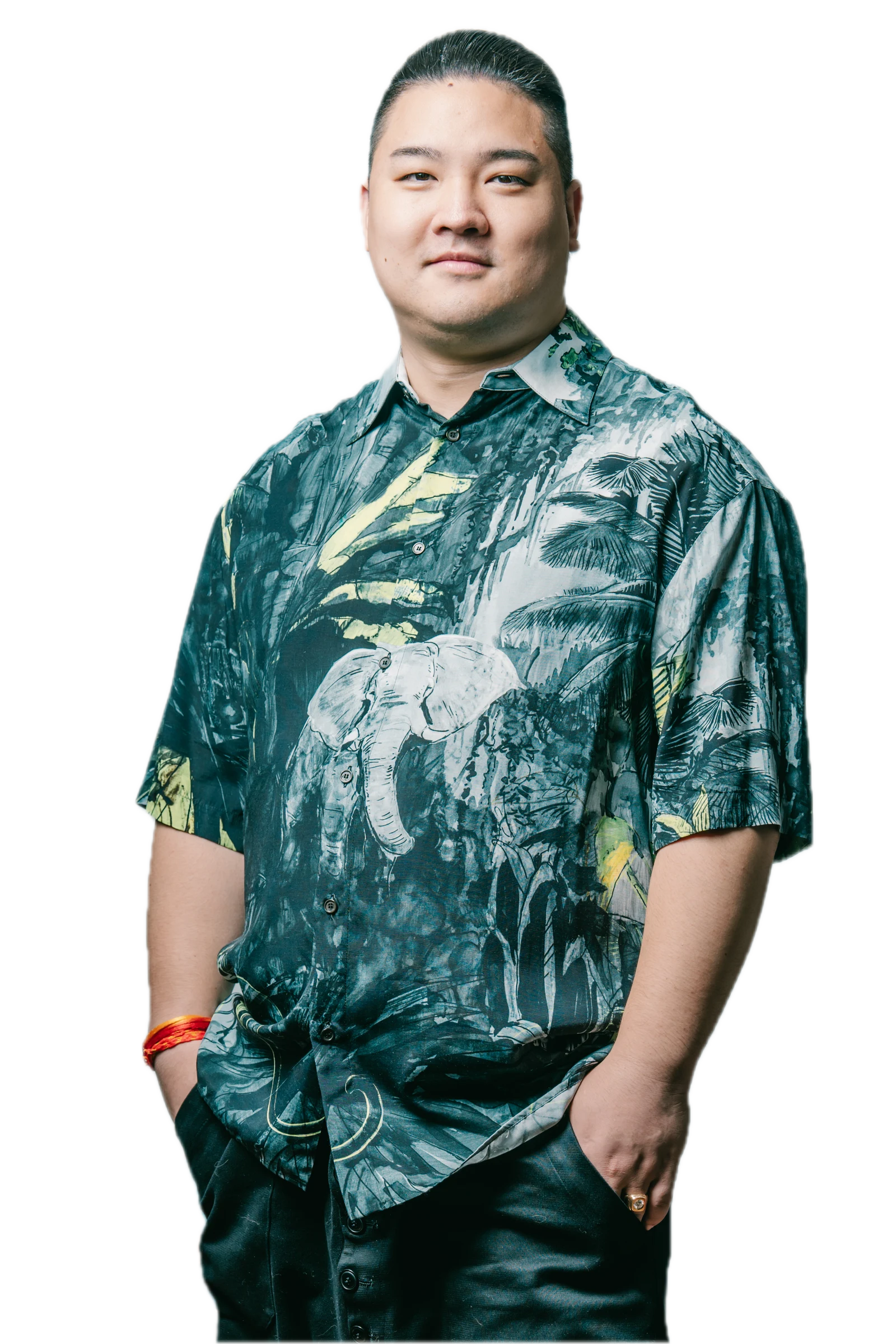 深い青緑の象柄シャツを着た主宰・望月俊亮
